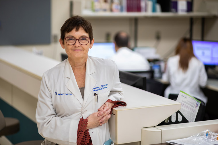 Dr. Elkins leaning on a counter at a nurses' station.